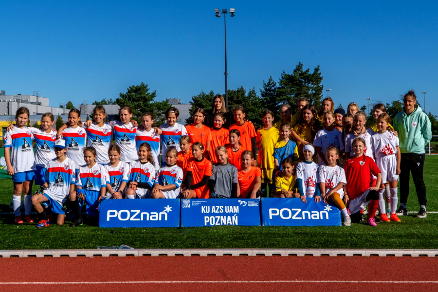 Jesienna edycja Poznańskiej Ligi Orliczek 2025 - na trawie pozują drużyny biorące udział w rozgrywkach na tle logotypów