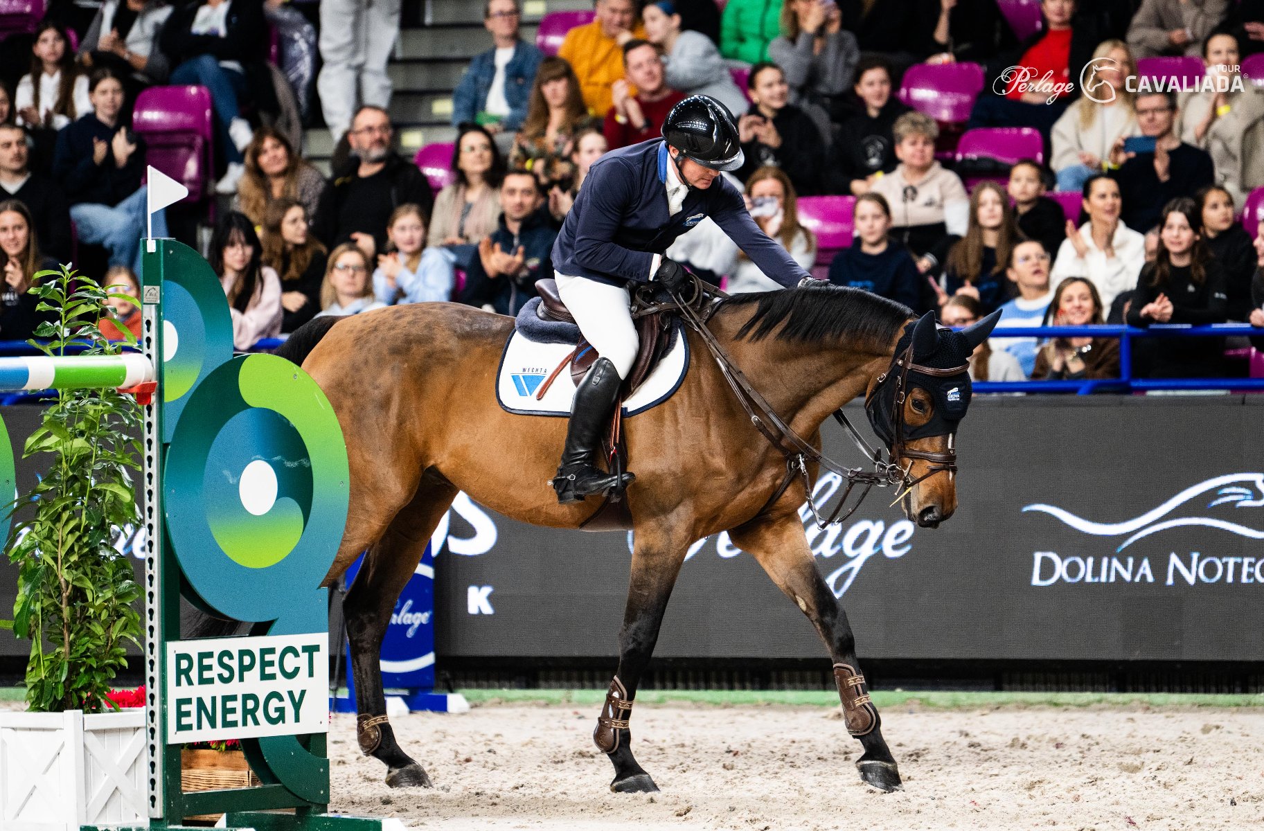 Maksymilian Wechta, fot. Kamila Tworkowska - zawodnik jedzie na koniu po arenie, w tle widać ludzi na trybunach
