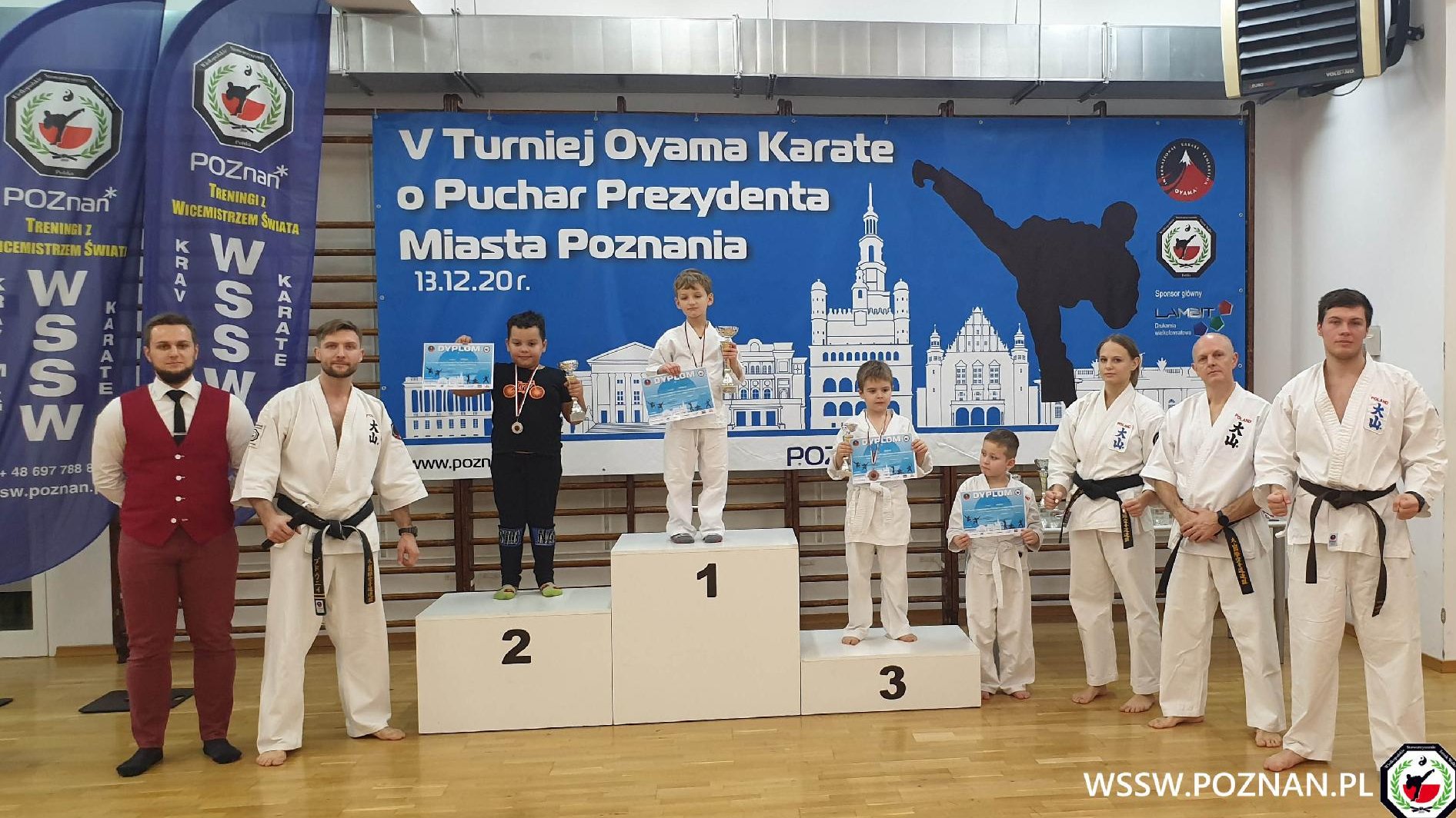 Młodzi zawodnicy z medalami i dyplomami na podium - grafika artykułu