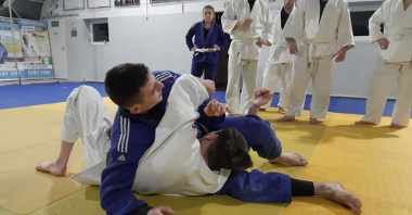 zawodnicy w białym i niebieskim judogo podczas pokazu walki na macie