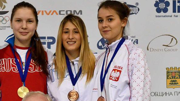 zawodniczki z medalami na podium poniżej trenerzy