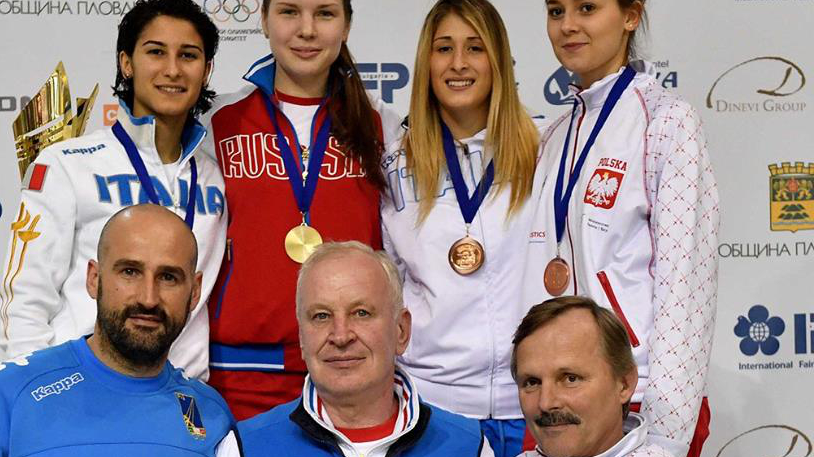 zawodniczki z medalami na podium poniżej trenerzy