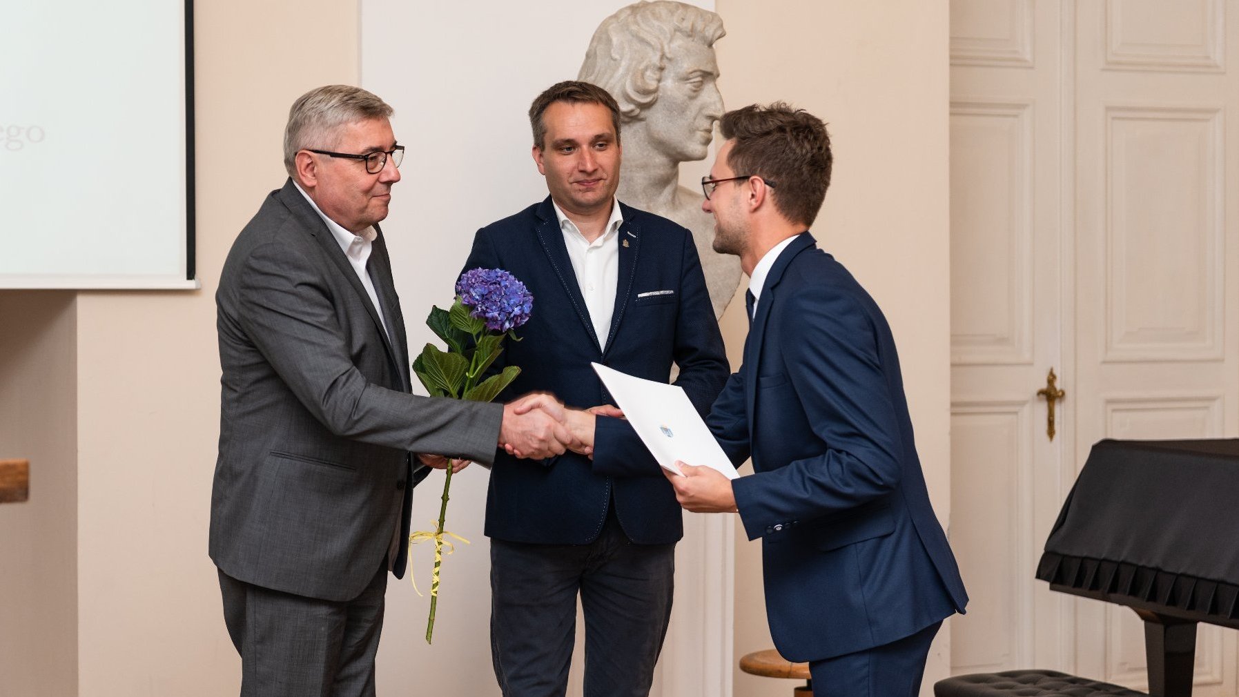 Zdjęcie przedstawia moment wręczenia stypendium laureatowi / laureatce