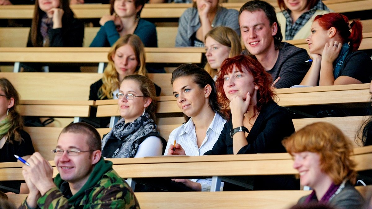 zdjęcie przedstawia studentki i studentów w ławkach na auli, słuchających wykładu - grafika artykułu