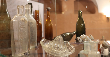 Na zdjęciu stare szklanek przedmioty, m.in. butelki oraz wyciskarka do cytryn