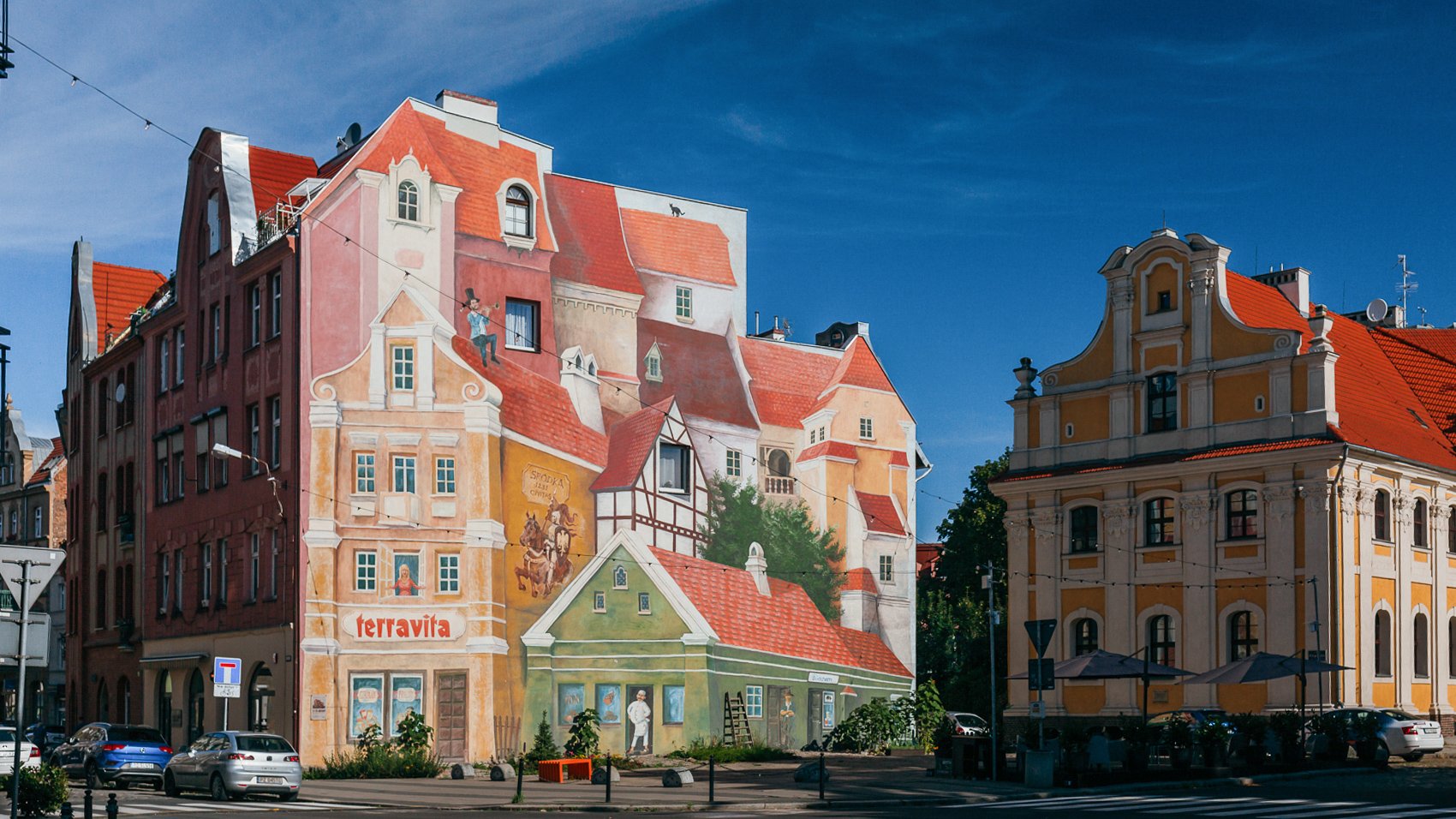 Kamienice. Na ścianie mural 3D, który przedstawia włoskie miasteczko.