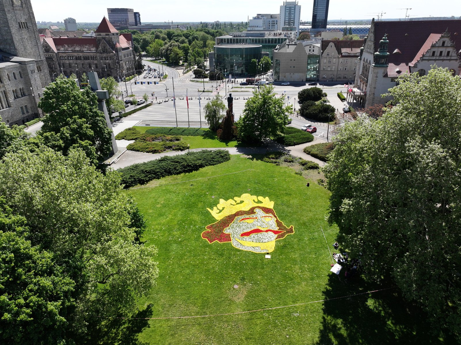 W parku Adama Mickiewicza od dziś do piątku można podziwiać dywan kwiatowy z wizerunkiem Chrobrego, fot. materiały SITO. Widok z lotu ptaka na park, w którego centrum znajduje się dywan z kwiatów z podobizną Bolesława Chrobrego w złotej koronie. Z tyłu widać Zamek Cesarski i budunek Uniwersytetu im. Adama Mickiewicza.
