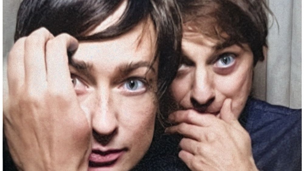 Photo of a man's and a woman's faces. They are touching their faces with their hands.