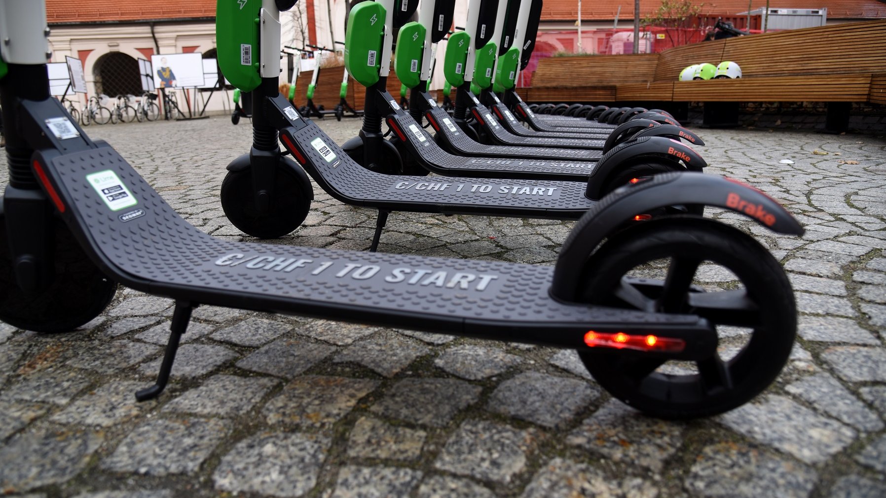 Picture of eight e-scooters. They are black, with white and green extras. - grafika artykułu