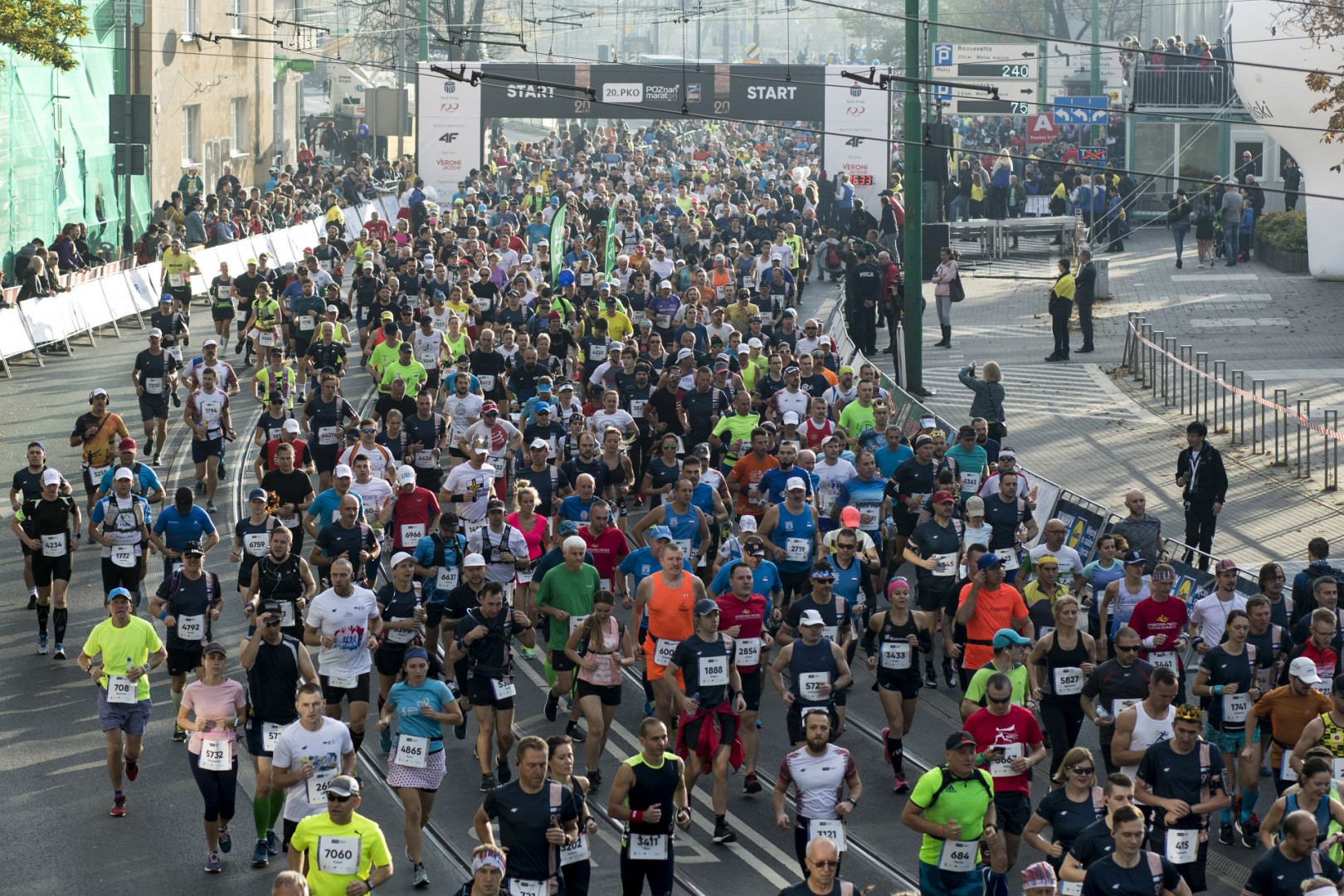 The picture shows runners during the Poznan Marathon. Crowd of people is running through the streets of Poznan. - grafika artykułu