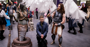 A young man standing between two people in disguise