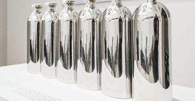 Photo of six silver bottles standing in a row.