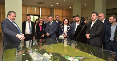 A group of people gathered around a model of city of Kutaisi, Georgia.