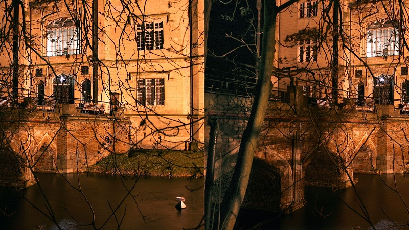 An illuminated building with a brick bridge leading to it. Water under the bridge.