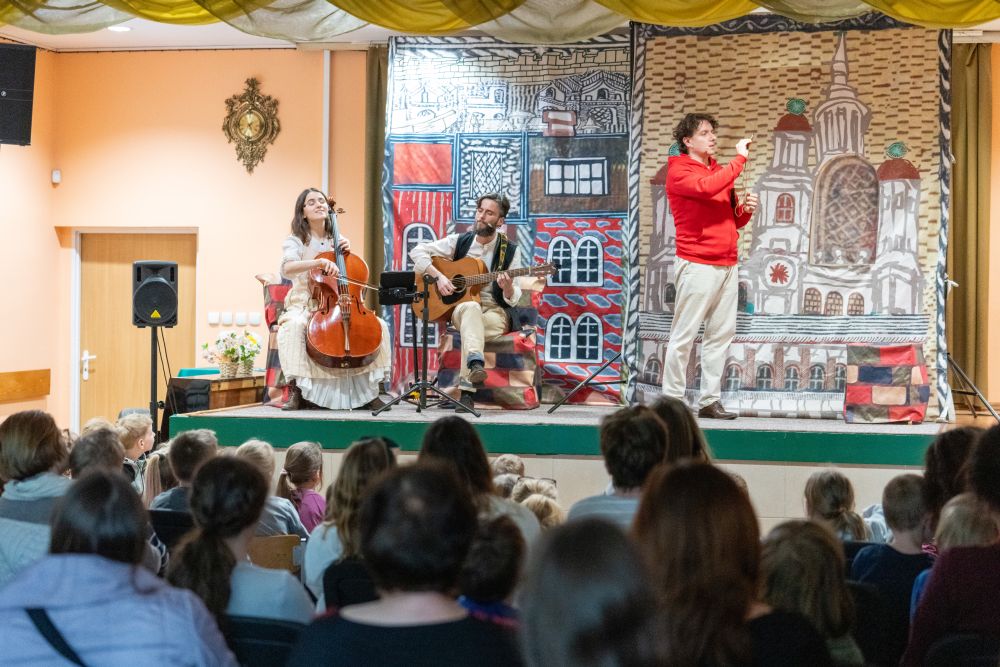 Aktorzy i muzycy występują na scenie.