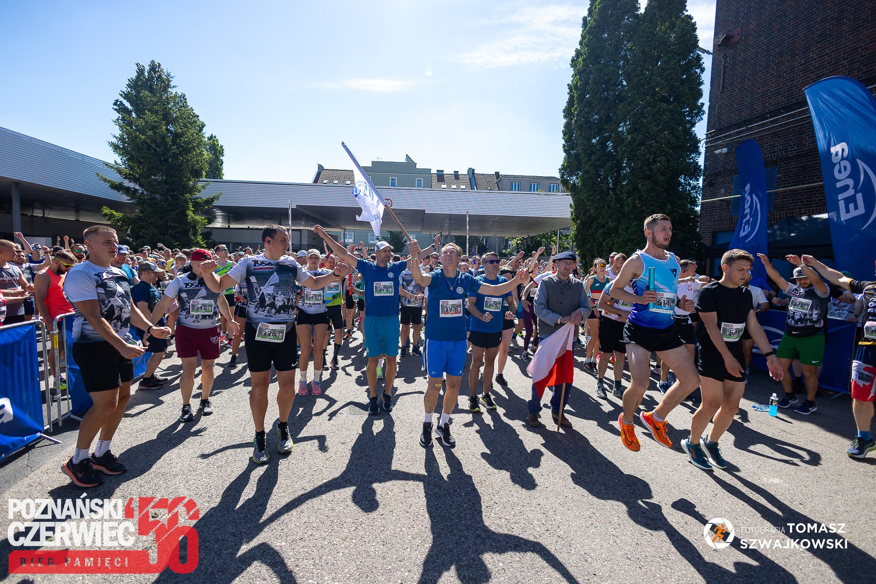 Bieg Czerwca '56 w 2024 roku, fot. Tomasz Szwajkowski Bieg Czerwca '56 w 2024 roku, fot. Tomasz Szwajkowski - tłum ludzi na starcie w strojach sportowych, niektórzy z flagami, a z boku stoją kibice