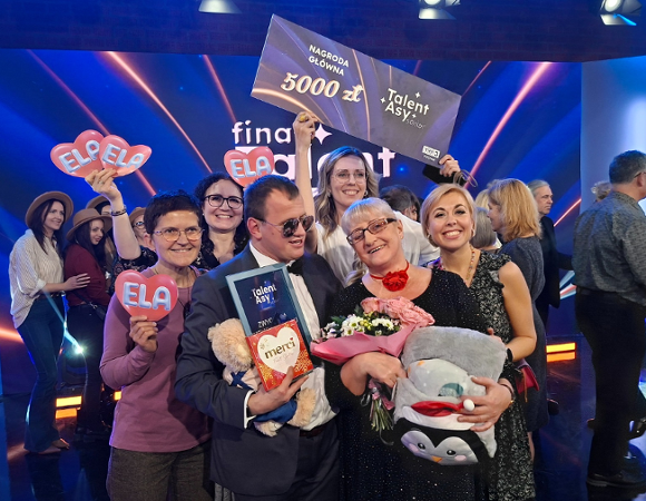 Elżbieta Maciejewska i Łukasz Pawlik z nagrodami i prezentami od bliskich, obok pracownicy "Klubu Winogrady" z serduszkami z napisem "ELA".