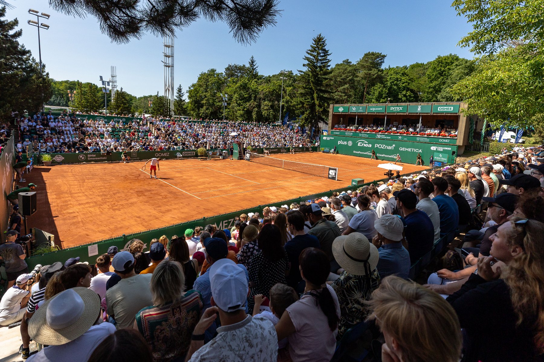 Enea Poznań Open 2025, fot. Paweł Rychter Enea Poznań Open 2025, fot. Paweł Rychter - widok na kort tenisowy w trakcie gry 2 tenisistów oraz pełne trybuny przy słonecznej pogodzie