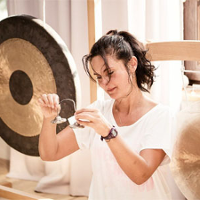 Kobieta grajaca na gongach.