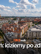 Zdjęcie z lotu ptaka, fragment miasta z kamienicami, ulicami i parkami.