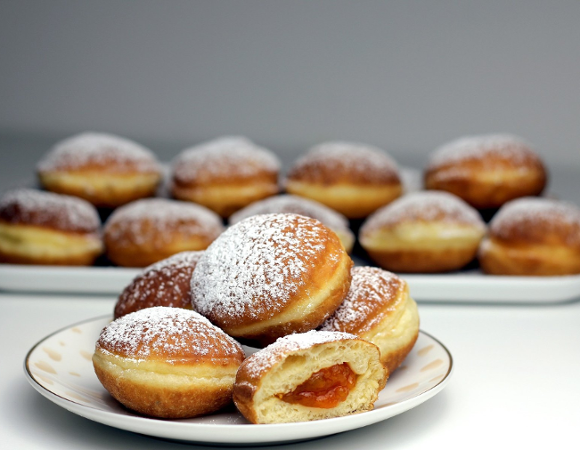 Liczne pączki posypane cukrem pudrem.