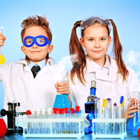 Mali naukowcy: chłopiec i dziewczynka w kitlach wykonują doświadczenia.