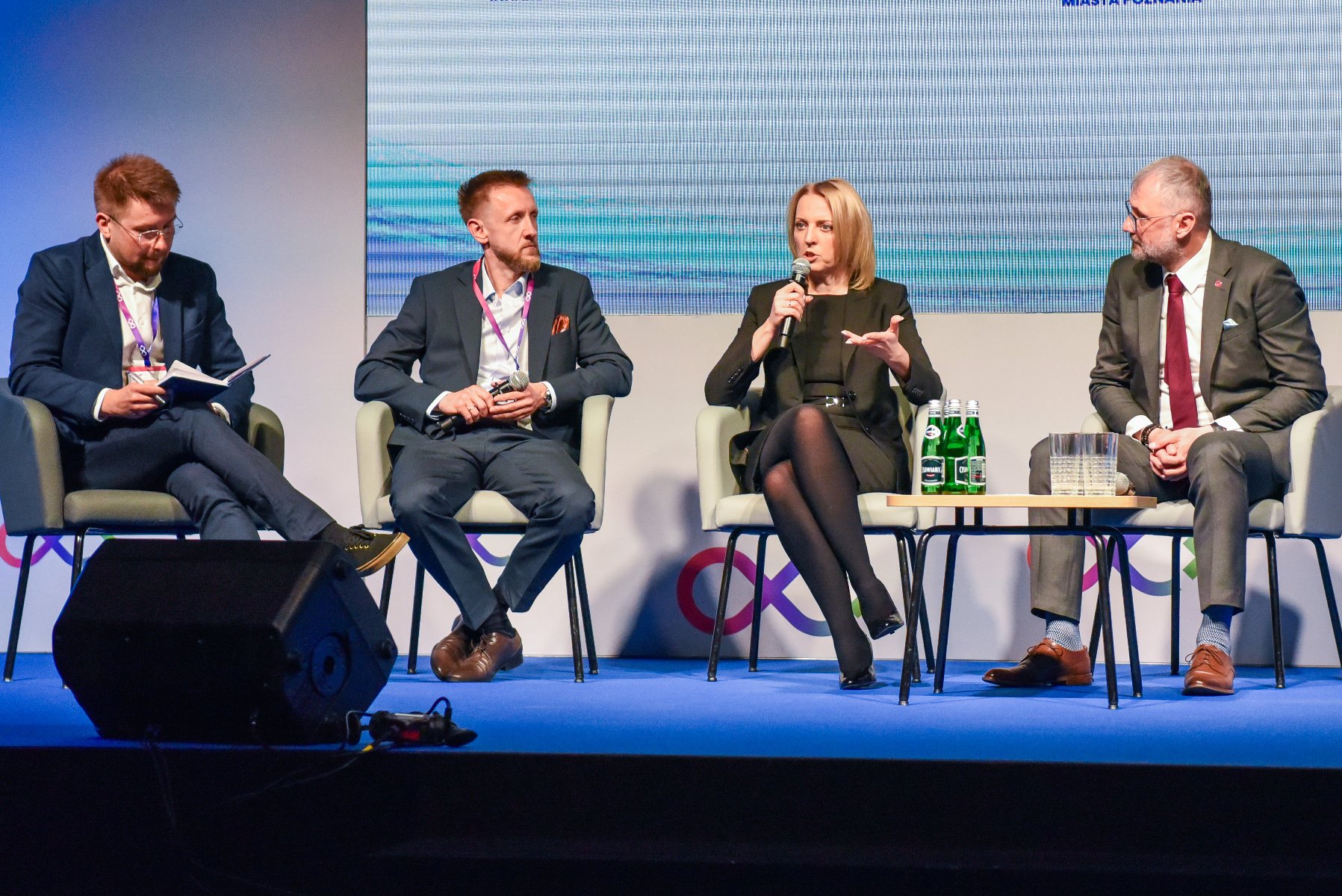 Ruszyły NetZero Energy i H2Poland 2025 Na zdjęciu trzech mężczyzn i kobieta rozmawiają ze sobą, siedząc na krzesłach, kobieta trzyma mikrofon