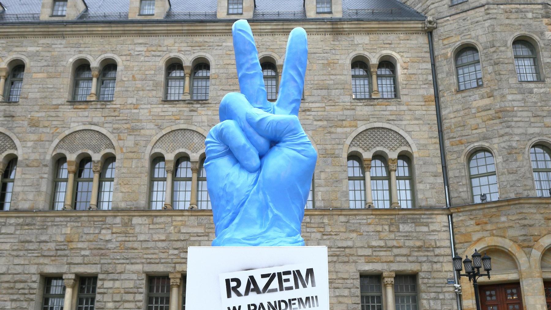 Na zdjęciu widać palce ułożone w znany z historii symbol zwycięstwa, ubrany w antywirusową niebieską rękawiczkę. Na nim napisy: Imieniny Ulicy. Jest inaczej. - grafika artykułu