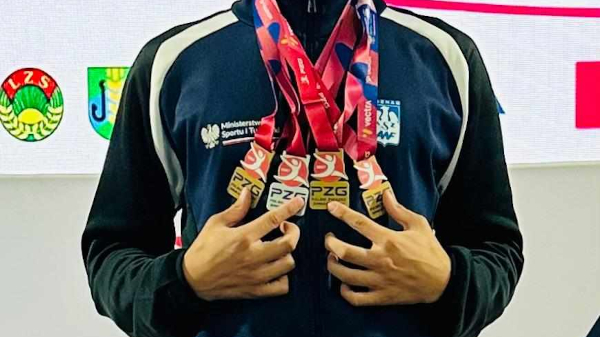 Bartłomiej Wiśniewski z medalami na MMP i MPJ w gimnastyce - stoi zawodnik, a na szyi ma 4 medale