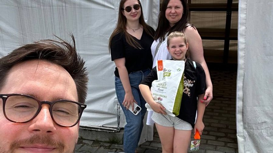 Selfie czterech osób. Trzymają karmę dla zwierząt.