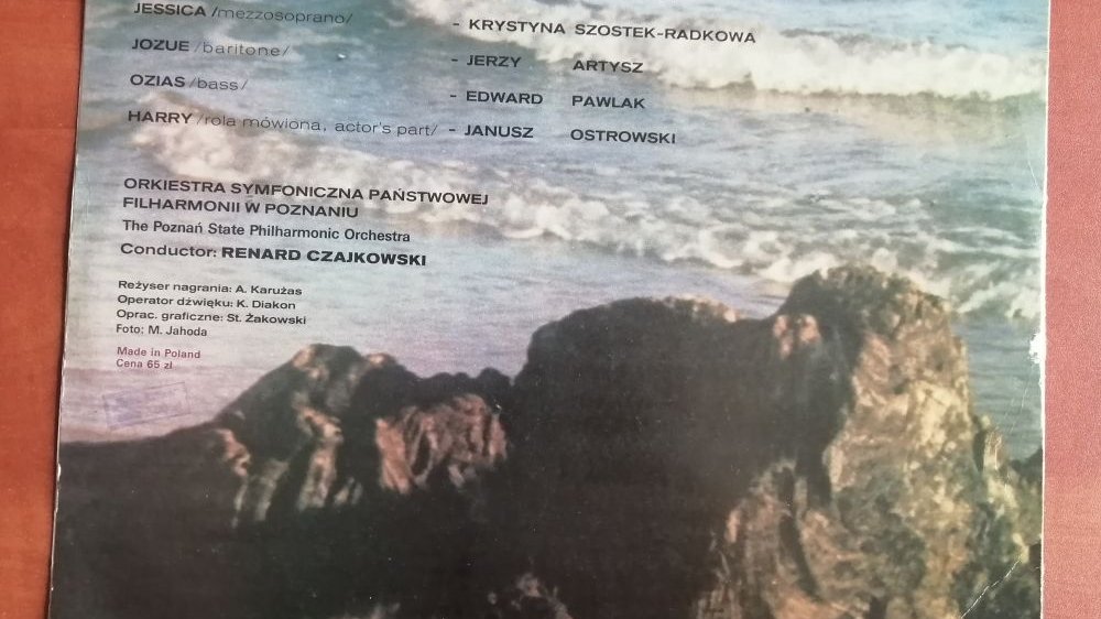 Tył okładki płyty ze zdjęciem brzegu morza i napisami na zdjęciu.