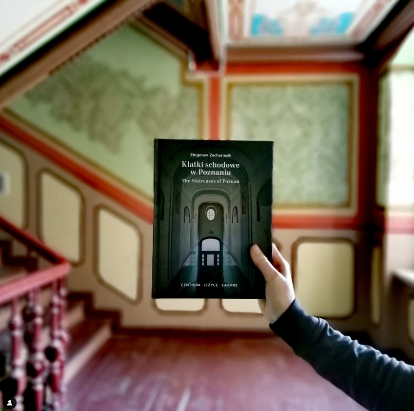 Okładka książki na tle zabytkowej kolorowej, klatki schodowej w jednej z poznańskich kamienic. - grafika artykułu