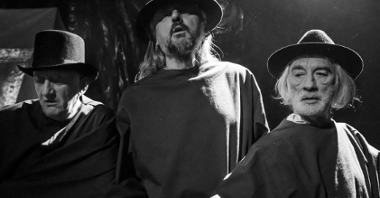 Czarno-białe zdjęcie trzech aktorów w kapeluszach na głowach, stojących obok siebie.