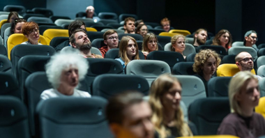 Widzowie siedzą w kinie, widzimy ich twarze. Część miejsc jest pusta.