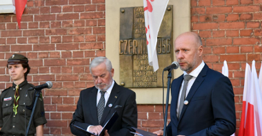 Bartosz Guss, zastępca prezydenta Poznania przy mikrofonie, za nim tablica poświęcona bohaterom Czerwca '56, obok konferansjer i harcerka