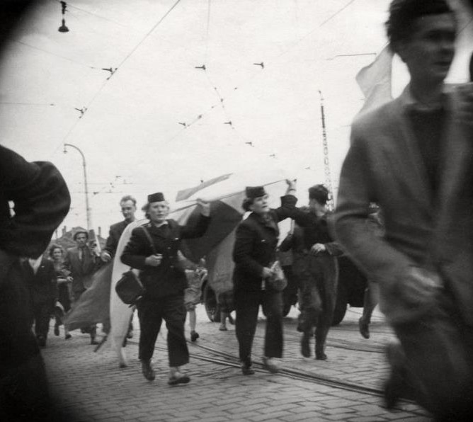 Trzy Tramwajarki niosące w dłoniach biało-czerwony sztandar w dniu 28.06.1956. Są to od lewej: Stanisława Sobańska, Helena Przybyłek i Maria Kapturka. - grafika artykułu