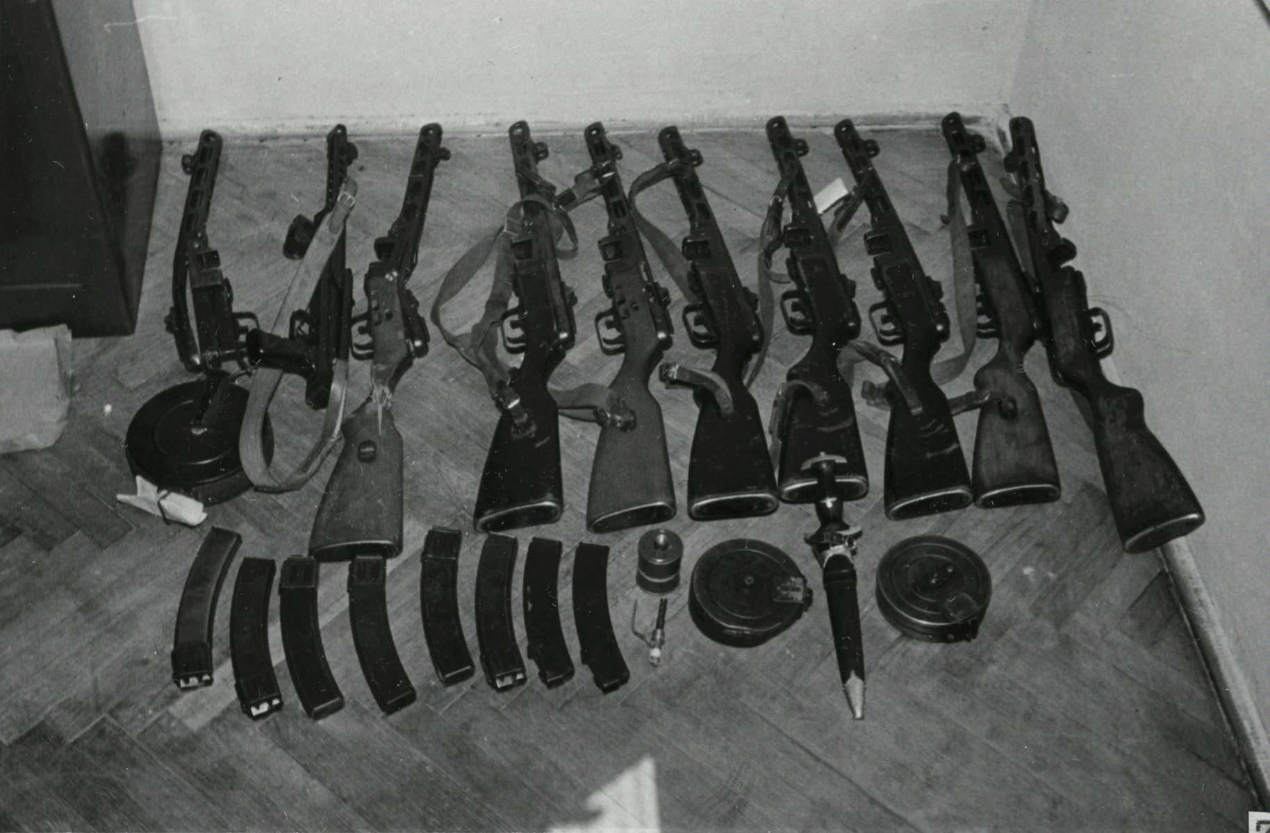 Czarno-biała fotografia kilku sztuk różnego rodzaju broni leżącej na podłodze pomieszczenia. Broń została użyta przez demonstrantów 28 czerwca 1956 roku podczas walk pod Wojewódzkim Urzędem do spraw Bezpieczeństwa. Fotografia była materiałem dowodowym w aktach śledczych procesów. - grafika artykułu