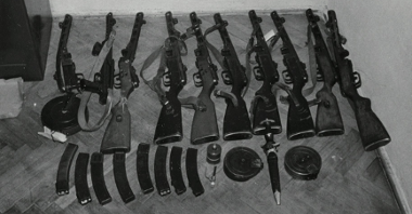 Czarno-biała fotografia kilku sztuk różnego rodzaju broni leżącej na podłodze pomieszczenia. Broń została użyta przez demonstrantów 28 czerwca 1956 roku podczas walk pod Wojewódzkim Urzędem do spraw Bezpieczeństwa. Fotografia była materiałem dowodowym w aktach śledczych procesów.
