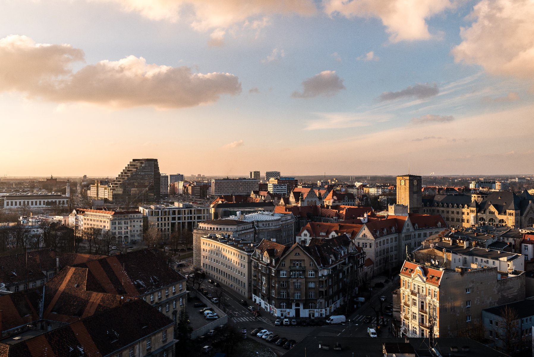 Zdjęcie przedstawia widok z lotu ptaka na centrum Poznania, nad którym zachodzi słońce. - grafika artykułu