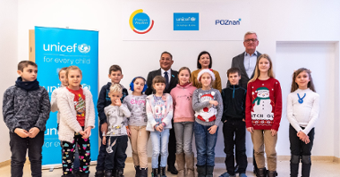 Na zdjęciu prezydent Poznania i przedstawiciel UNICEF z dziećmi, pozują