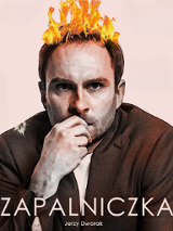 na zdjęciu mężczyzna patrzący w obiektyw, przykłada prawą rękę do ust. Na głowie ma na włosach ogień.