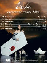 Plakat koncertowy. Na pierwszym planie stoi kobieta w srebrzystym stroju, której stopy są zanurzone w wodzie. Kobieta trzyma dużą papierową kopertę ozdobioną czerwoną pieczęcią w kształcie serca. Obok niej unosi się papierowa łódka. W tle widać ciemne chmury nad linią drzew o zachodzie słońca. Powyżej postaci informacje o trasie koncertowej.