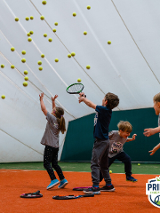 Czworo dzieci bawi się piłkami do tenisa.