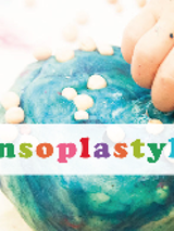 Plakat, rączki dziecka bawią się plasteliną, przyklejają białe kuleczki do dużej kuli. Na środku kolorowy napis Sensoplastyka.