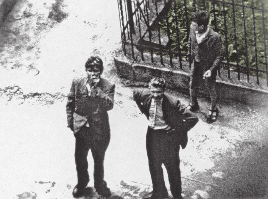 Zdjęcie z góry: trzej mężczyzni na ulicy.