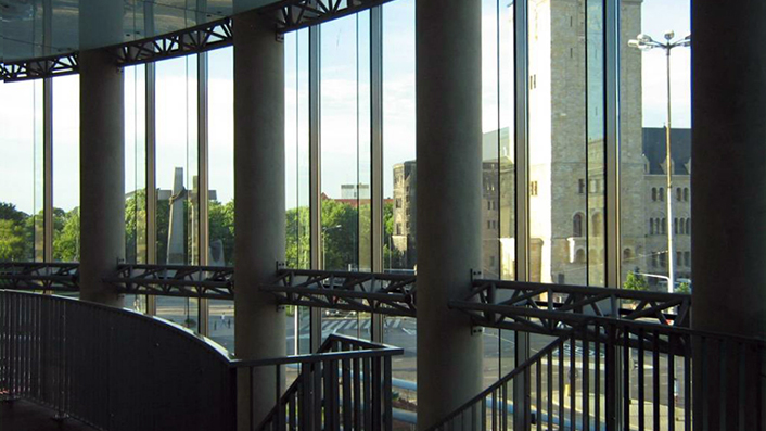 Zdjęcie przedstawia widok na CK Zamek i pl. Mickiewicza z przeszklonego foyer budynku sali koncertowej Akademii Muzycznej.