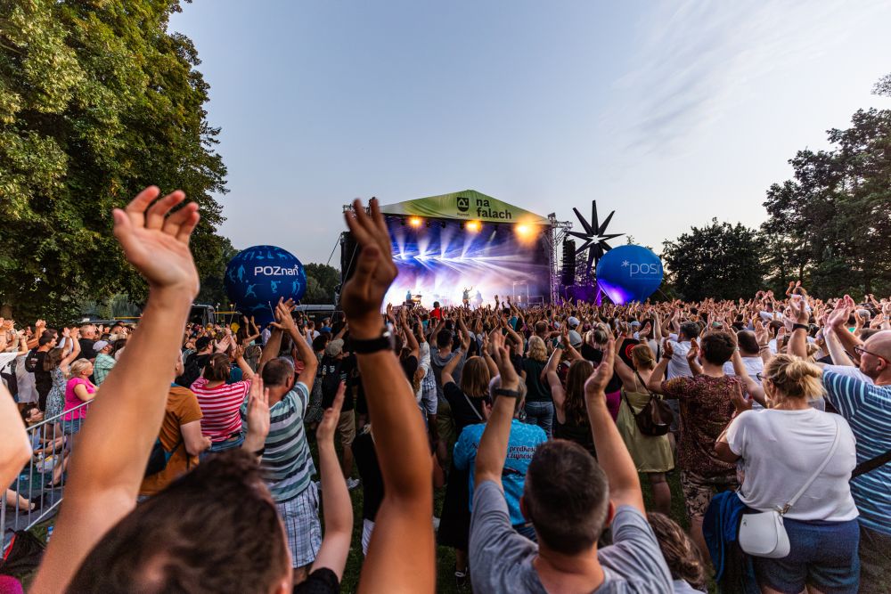 Scena nad Rusałką 2024, fot. materiały prasowe Scena rozświetlona na różowo, występuje na niej zespół, w centrum wokalista, który trzyma też gitarę klasyczną.