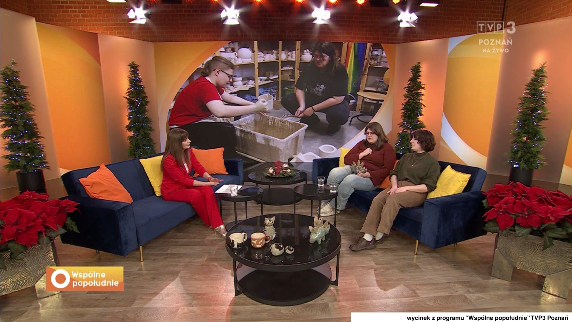 Trzy osoby siedzą na kanapach w studiu telewizyjnym, rozmawiając na temat aktualnych wydarzeń.