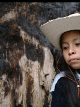 Kadr z filmu "Valentina i spokój", na zdjęciu dziewczynka w dużym słomkowym kapeluszu, dookoła niej skały.