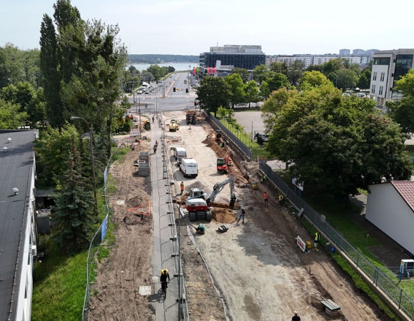 Widok z lotu ptaka na skrzyżowanie ulic, gdzie trwają prace nad budową ścieżki dla rowerzystów i pieszych, która połączy mosty Berdychowskie ze skrzyżowaniem ulic Berdychowo, Jana Pawła II i Baraniaka